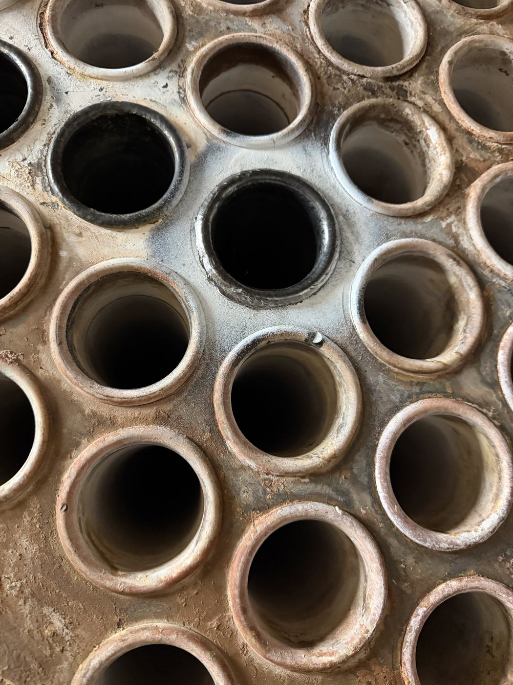 Close-up of fouled fire-tube boiler tubes with heavy scale deposits